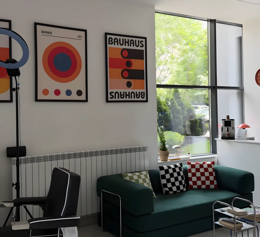 Интериор на ELEMENT Barbershop — модерно пространство с тъмнозелен диван, Баухаус арт принт и синя витрина